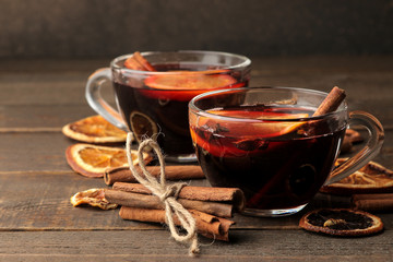 Hot mulled wine with cinnamon and orange in glass cups against a dark background. Christmas. new Year.