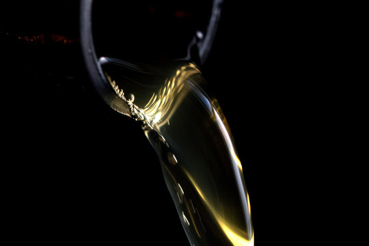 Close up of beer pouring against black background