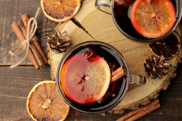 Hot mulled wine with cinnamon and orange in glass cups against a dark background. Christmas. new...