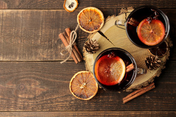 Hot mulled wine with cinnamon and orange in glass cups against a dark background. Christmas. new Year. top view with space for text