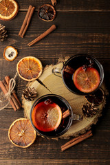 Obraz na płótnie Canvas Hot mulled wine with cinnamon and orange in glass cups against a dark background. Christmas. new Year. view from above