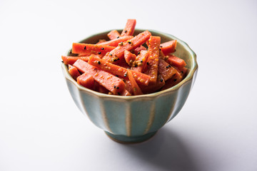 Carrot Pickle / Gajar ka Achar or Loncha in hindi. Served in a bowl over moody background. Selective focus