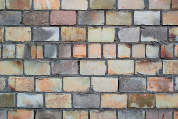 Worn brick wall of different color blocks