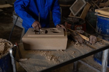 Worker making foundry molding in workshop