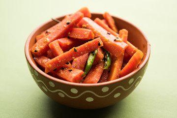Carrot Pickle / Gajar ka Achar or Loncha in hindi. Served in a bowl over moody background. Selective focus