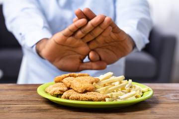Man Refusing Friend Food On Plate
