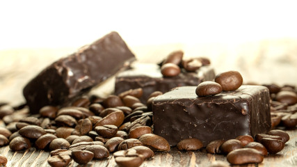 Chocolates and coffee seeds on wooden background