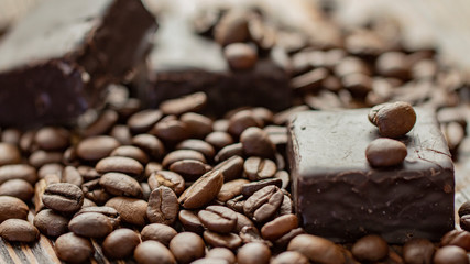 Chocolates and coffee seeds on wooden background