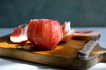 Close up of peeled grapefruit on wooden cutting board