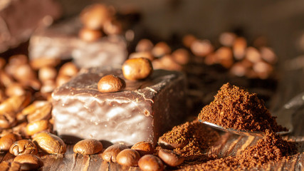 Chocolates and coffee seeds on wooden background