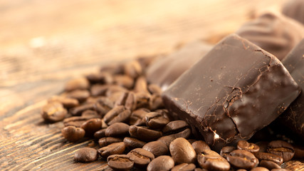 Chocolates and coffee seeds on wooden background