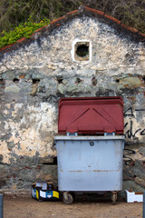 Garbage container in front of an old house