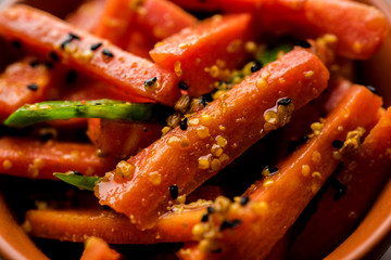 Carrot Pickle / Gajar ka Achar or Loncha in hindi. Served in a bowl over moody background. Selective focus