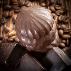 Chocolates and coffee seeds on wooden background