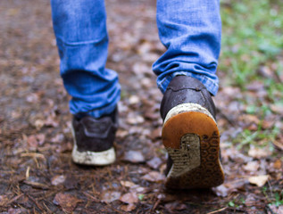 man walking in the woods. sneakers close up. step in motion