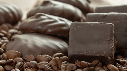 Chocolates and coffee seeds on wooden background