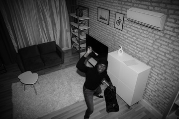 Thief With Bag And Crowbar In House