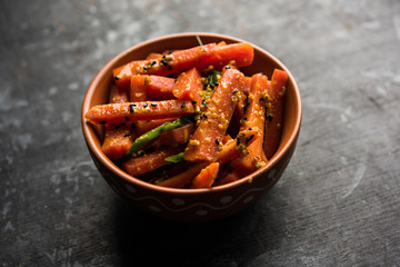 Carrot Pickle / Gajar ka Achar or Loncha in hindi. Served in a bowl over moody background. Selective focus