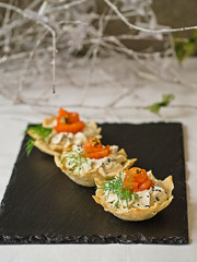 Tartlets with cream cheese and smoked salmon. Festive New Year's dish. Christmas snack. Close up, copy space, selective focus