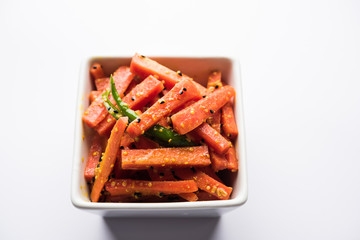 Carrot Pickle / Gajar ka Achar or Loncha in hindi. Served in a bowl over moody background. Selective focus
