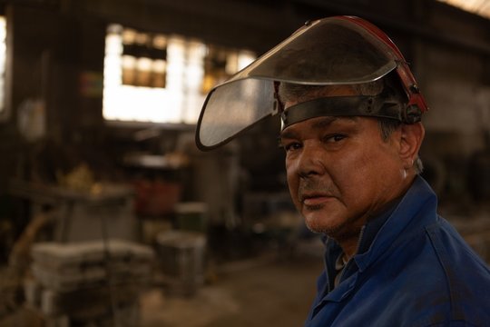 Worker looking at camera in foundry workshop