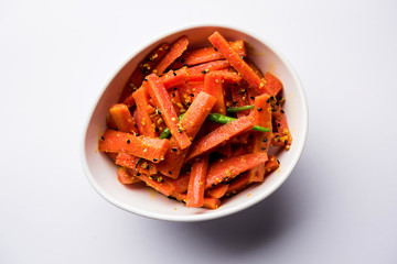 Carrot Pickle / Gajar ka Achar or Loncha in hindi. Served in a bowl over moody background. Selective focus