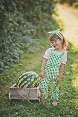 A little girl carries a huge watermelon on a cart 1885.