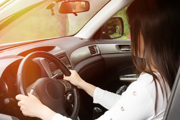 Young girl with long dark hair driving a car