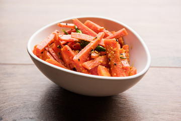 Carrot Pickle / Gajar ka Achar or Loncha in hindi. Served in a bowl over moody background. Selective focus
