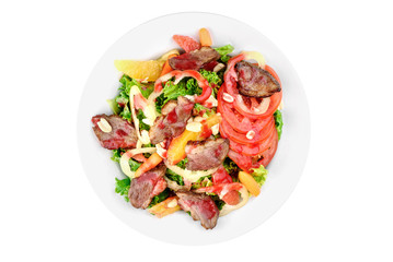 Salad with meat, pear, tomato, on a white plate isolated on white background