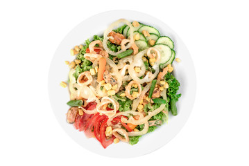 Salad with mussels, squid, bell pepper, tomatoes, corn, cucumbers and asparagus in a white plate