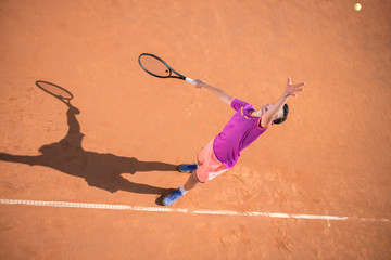 Young tennis player serving the ball