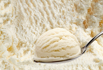 Vanilla ice cream in spoon on ice cream background  