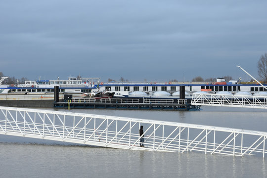 boten en een overstroomde loopbrug door hoogwater in een haven bij de rivier de Rijn 