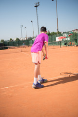 Young tennis player prepares for serving the ball