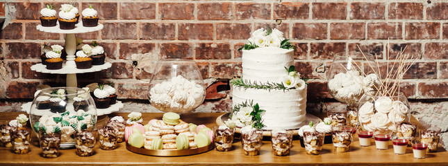 Fototapeta na wymiar Wedding catering, table with modern desserts and cupcakes.