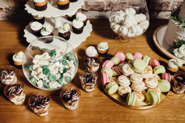 Wedding catering, table with modern desserts and cupcakes.