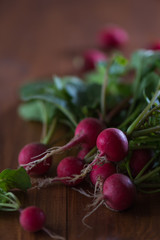Bunch of radishes on a wooden table in the low key