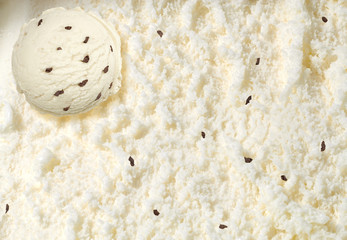 Vanilla ice cream scoop with chocolate chips or parts on spooned ice cream background  