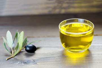 Olive oil and olive branch on the wooden background, apulian olive oil