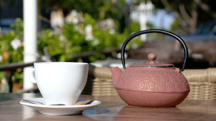 cup of tea and teapot on a terrace