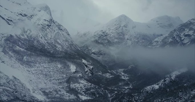 Winter Aerial shot of majestic mountains covered by fog in Olden, Norway