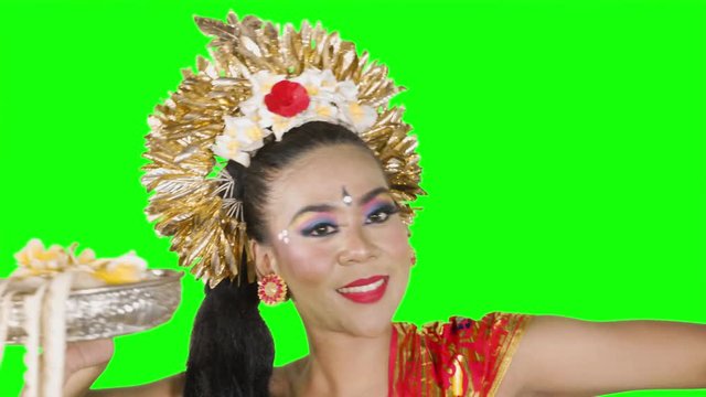 Close up of Balinese female dancer performing artistic dance in colorful costume. Shot in 4K over green screen