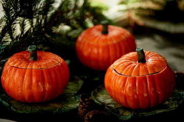 Handmade ceramics in the form of pumpkins. Christmas paws. The atmosphere of celebration and home comfort . Cheerful orange pots to the oven and roast.