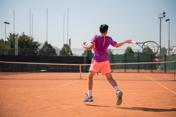 Young tennis player playing forehand