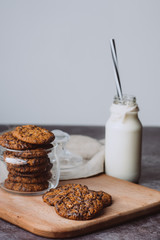 Glass with fresh milk and homemade chocolate chips cookies over a  on wooden table. Breakfast 