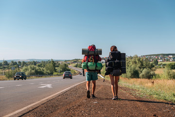 Travel man hitchhiking. Backpacker on road