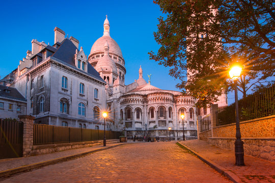 Fototapeta Empty cozy street and the Sacre-Coeur Basilica during morning blue hour, quarter Montmartre in Paris, France