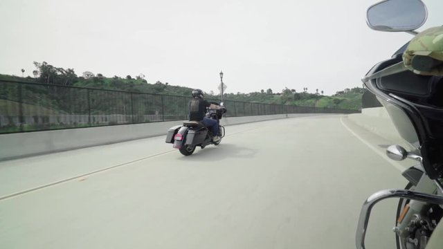 Harley Riders Cruising Down Street On Board