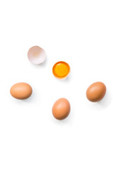 fresh brown organic chicken eggs broken with yolk and egg white isolated on white background. Vertical composition. Top view